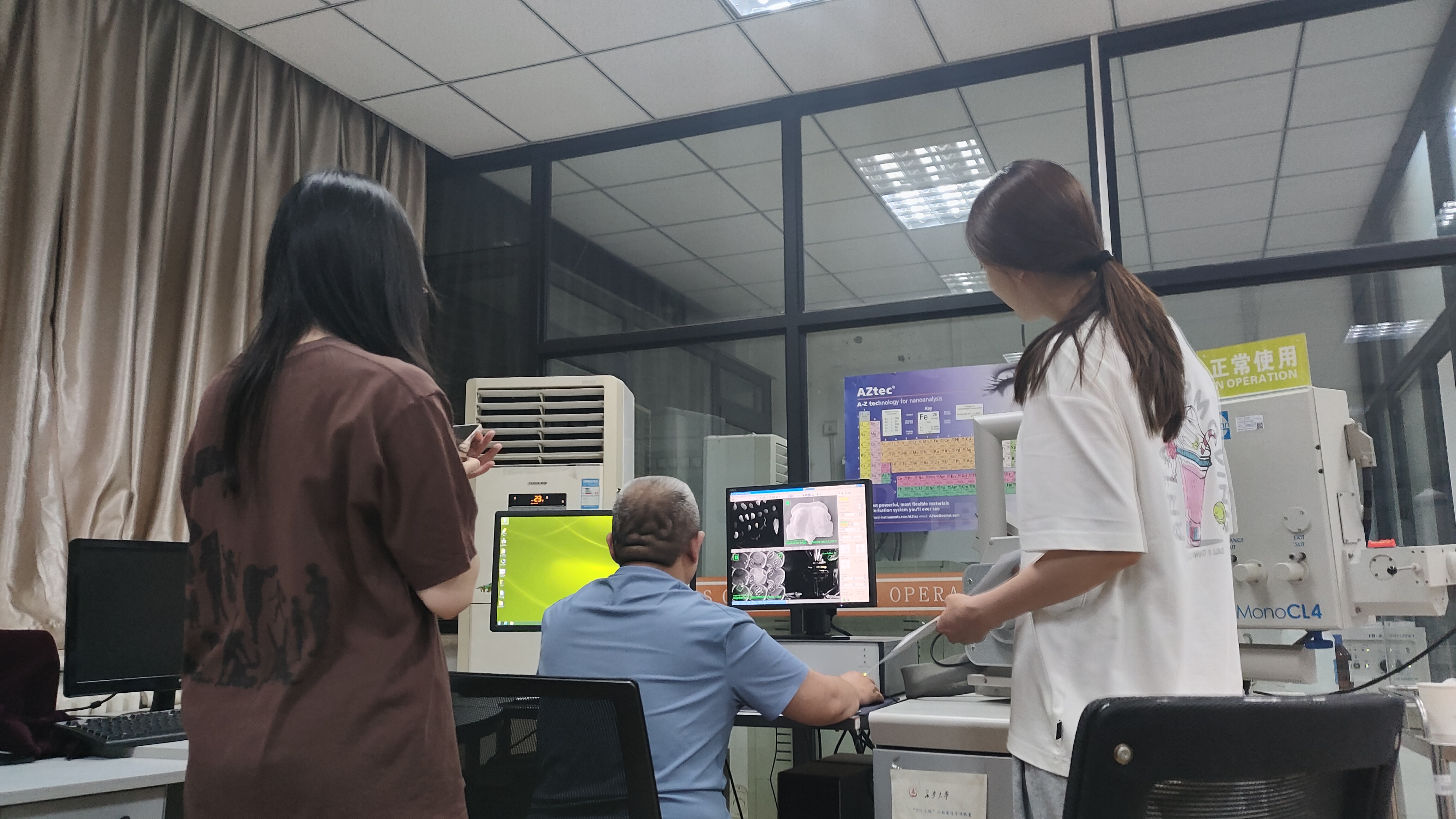 2023年郭俊锋（中）指导学生进行扫描电镜化石拍照