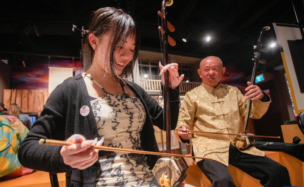 People try traditional Chinese musical instruments in Vancouver